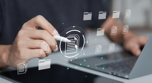 Osoba korzystająca z tabletu i laptopa, trzymająca elektroniczny rysik, wokół której widoczne są graficzne ikony cyfrowych dokumentów i folderów symbolizujące zarządzanie plikami online.